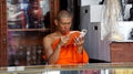 Buddhist monk is reading a book inside a shop