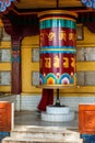 Buddhist monk rotating big prayer wheel