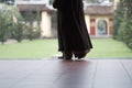 Buddhist monk`s bare feet in traditional vestments