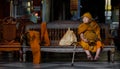 Buddhist Monk sits on a bench at Wat Phra Doi Suthep