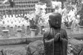 Black and white stone statue of Buddhist monk standing and praying Royalty Free Stock Photo