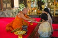 The Buddhist monk ties a string amulet on a hand to the woman in the Buddhist temple. Bangkok Royalty Free Stock Photo