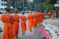 Buddhist monk walking with bowl to receive alms food from people