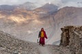 Buddhist monk walking road mountain village India clouds Royalty Free Stock Photo