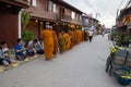 Buddhist monk walking to let people put food offerings in an alms bowl for good merit Royalty Free Stock Photo