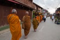 Buddhist monk walking to let people put food offerings in an alms bowl for good merit Royalty Free Stock Photo