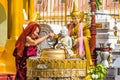 Buddhist monk watering buddha statue Shwedagon Pagoda