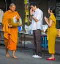 Buddhist monks collect offerings on a city street