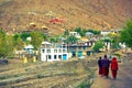 Buddhist monks go along narrow street of Kaza