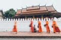 Buddhist monks during Laotian traditional sacred alms giving ceremony in Luang Prabang city, Laos