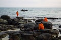 Buddhist monks on rocks beach on sunset Royalty Free Stock Photo
