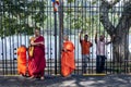 Buddhist monks stand inside the Temple of the Sacred Tooth Relic.