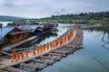 Buddhist monks walk on Bamboo Bridge