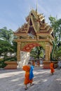 Buddhist monks walk in the beautiful Wat Inpeng temple in Vientiane, Laos