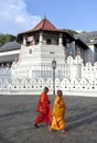 Buddhist monks walk past the Temple of the Sacred Tooth Relic in Kandy in Sri Lanka.
