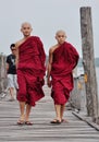 Buddhist monks walking on wooden bridge in Bagan, Myanmar