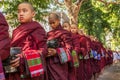 Buddhist novices walk to collect alms and offerings in Amarapura near Mandalay, Myanmar. This procession is held every day