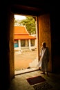 A Buddhist nun stands in a doorway of a temple in Bangkok, Thailand