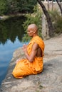 buddhist in orange robe meditating in