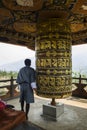 Buddhist pilgrim praying with a prayer wheel in Chimi Lhakang Monastery, Bhutan Royalty Free Stock Photo