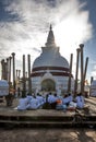 Buddhist pilgrims worship in front of the Thuparama Dagoba at Anuradhapura in Sri Lanka.