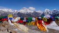 Buddhist prayer flags flying in the wind on the top of Renjo La pass, Himalayas, Nepal with mountain panorama.