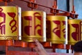 Buddhist prayer wheels in Tibetan monastery with written mantra. India, Himalaya, Ladakh, Buddhist prayer drums with close-up mant Royalty Free Stock Photo