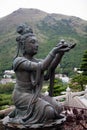 Buddhist Statue Making an Offering of Fruit Royalty Free Stock Photo