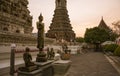 Buddhist statue standing in front of the ancient tiled Wat Arun temple, Bangkok, Thailand Royalty Free Stock Photo