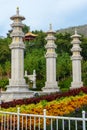 Buddhist stone pillars prayer flags columns on the territory of Buddhist center Nanshan on a cloudy day