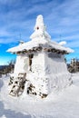 Buddhist stupa covered with snow on mountain top