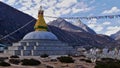 Buddhist stupa in a valley near Thame, Khumbu, Himalayas, Nepal with prayer flags flying in the wind and a wall of mani stones. Royalty Free Stock Photo