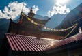 Buddhist temple rooftop with prayer flags amidst scenic mountains, Reckong Peo, Himachal Pradesh, India