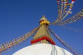 Buddhist Tibetan stupa Bodnath in Kathmandu with multicolored prayer flags against a clean blue sky Royalty Free Stock Photo