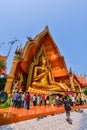 Buddhist tourists worshiping outdoor golden Buddha image