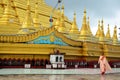 Buddhist woman ascetic or nun walking at Shwemawdaw Paya Pagoda in Bago, Myanmar.