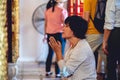Buddhist woman praying to Buddhist idols with incense near the altar in Hanoi City, Vietnam