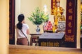 Buddhist worshiper praying at the altars of Buddhist idols with incense and chant in Hanoi, Vietnam.