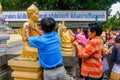 Buddhists gilding gold leaf on the face of Buddha staue