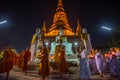 Buddhists people walking with lighted candles in hand around a ancient temple