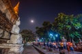 Buddhists people walking with lighted candles in hand around a ancient temple