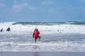 Bude, Cornwall UK July 6 2020. Lifeguard runs to sea to provide first aid to sinking surfer Royalty Free Stock Photo