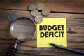 Budget Deficit. Euro cash and magnifying glass on a wooden background Royalty Free Stock Photo