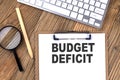 ANNUAL BONUS words on a clipboard, with calculator, magnifier and pencil on the white wooden background