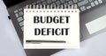 BUDGET DEFICIT - Top view notebook writing on the laptop Royalty Free Stock Photo