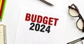 BUDGET 2024 on paper sheet and glasses with pen