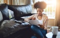 Budget, paperwork and black woman in home with bills, document and reading investment report. Wealth, savings or person Royalty Free Stock Photo