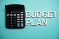Budget Plan alphabet letters with calculator on blue background Royalty Free Stock Photo