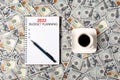 2022 budget planning banner with copy space. Notepad, pen and a cup of black coffee isolated on money background Royalty Free Stock Photo