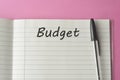 Budget planning concept. Top view of notepad with word Budget on pink minimalist background. Write idea success solution concept